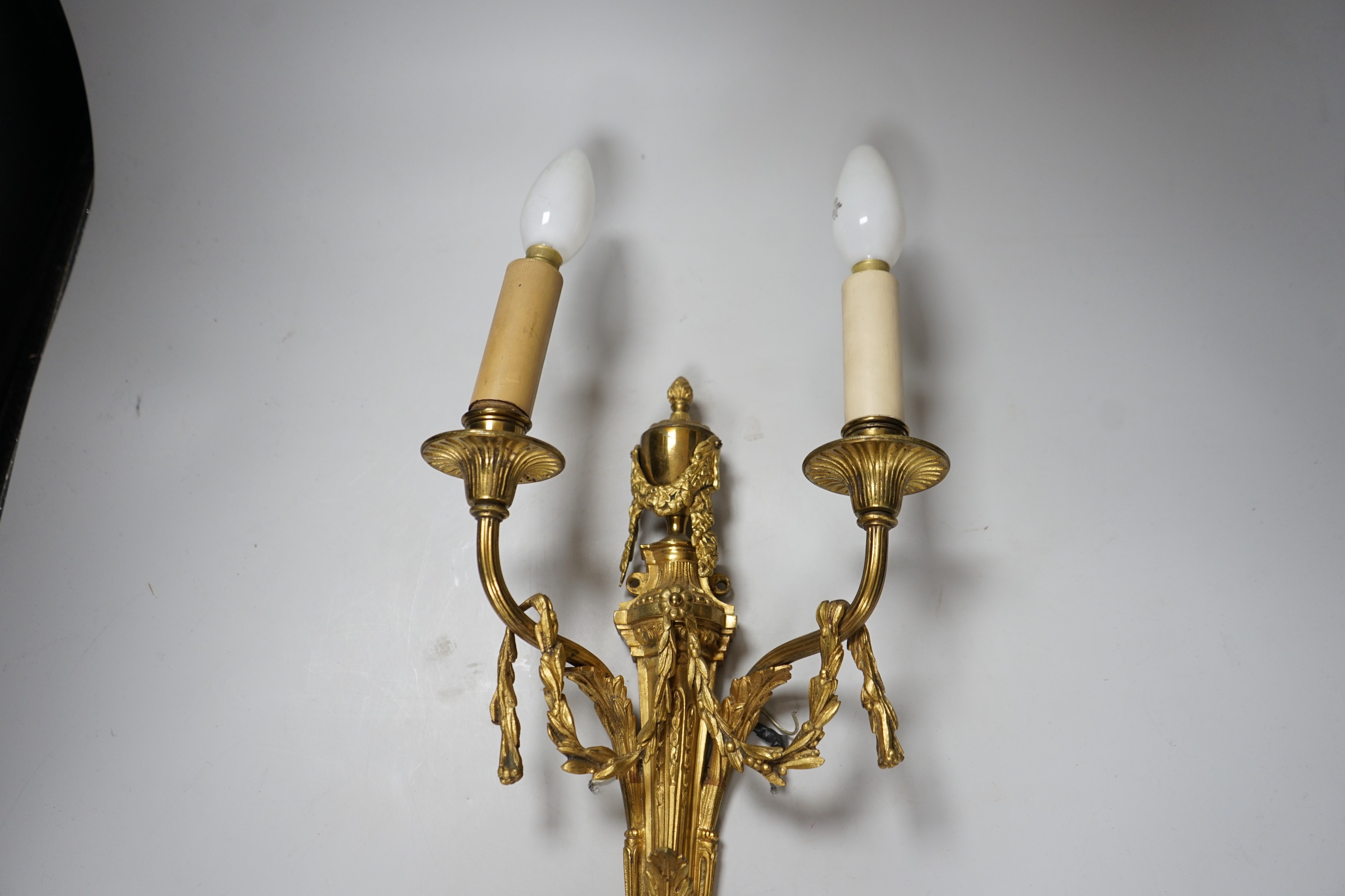 An ornate Louis XVI style gilt metal two branch wall sconce, 48 cm high including bulbs